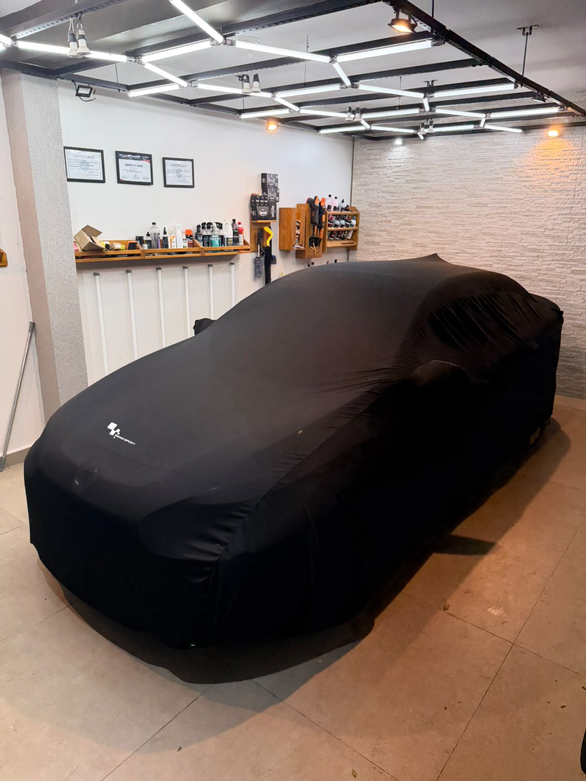 Capa automotiva preta ajustada ao formato de um veículo