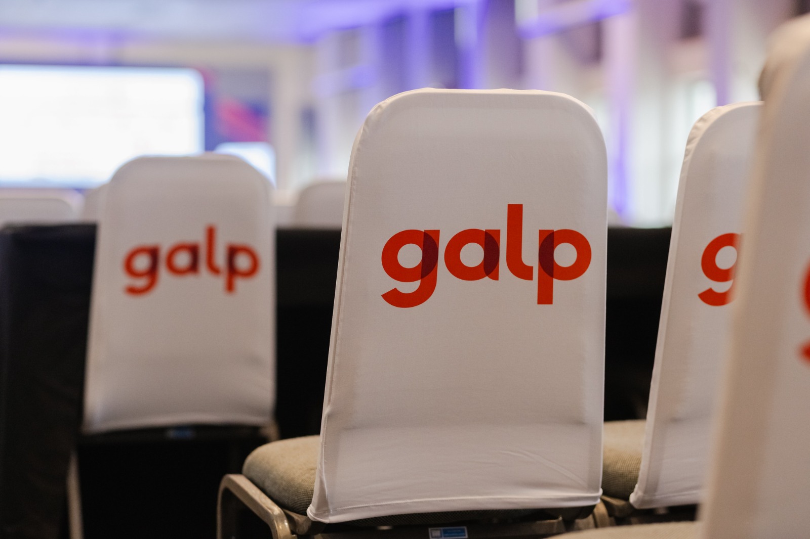 Detalhe de capa de cadeira branca personalizada com a marca Galp